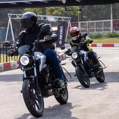 Two Revolt motorcycles captured mid-ride. This shot is great for showing the bike in a real-world context, appealing to riders who enjoy cruising together.