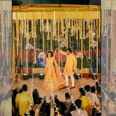 The couple's first dance at their sangeet, surrounded by guests and beautiful decor with fairy lights, creating a magical atmosphere.