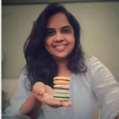 Here I am with a stack of my colorful, freshly baked eggless macarons. Baking is my passion, and I feel so much joy being able to share these sweet creations with you.