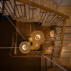 A view looking down the central stairwell, where a custom-designed cluster of cane pendant lights creates a cascade of warmth. This feature highlights my focus on vertical spaces and using lighting not just for function, but as a sculptural element that connects the home's different levels.