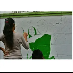 The initial sketch and color blocking phase of a public mural. This collaborative process involves outlining the figures and filling in the base colors before adding the finer details.