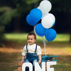 Mr. Onederful celebrating his first birthday outdoors! The natural greenery is a beautiful backdrop for this classic blue and white themed setup.