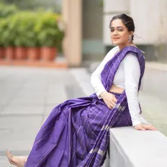 A full-length shot showing the graceful fall of the purple saree. This styling is perfect for an elegant daytime event.
