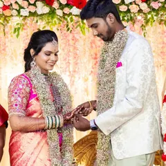 A candid moment from an engagement ceremony. The bride's pink silk saree is draped with neat, crisp pleats that stay in place, allowing her to enjoy her special moments without any worry.