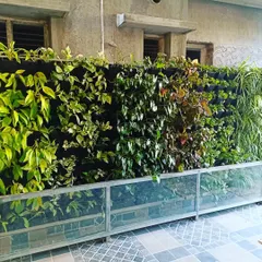This is a vertical garden created with a felt pocket system. This method allows for dense planting, and here you can see a variety of leafy green plants creating a lush, seamless wall of foliage.