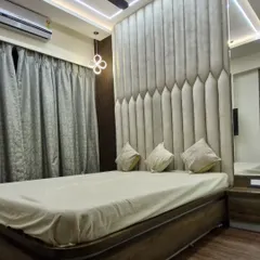 A floor-to-ceiling upholstered headboard makes a dramatic statement in this master bedroom. The vertical panels add a sense of height and luxury to the space.