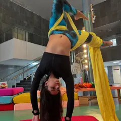 An inverted pose on the silks, showcasing the unique perspective and physical challenge that makes aerial fitness so rewarding.