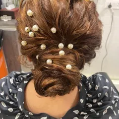 A modern take on a classic bun, this hairstyle is decorated with scattered pearls for a chic and contemporary feel. It's a versatile look that works for both Indian and Western outfits.
