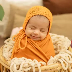 That sweet, sleepy smile is everything. I love swaddling babies to make them feel secure and cozy, which helps us capture these peaceful moments.