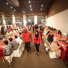 A wide view of a Shukraana party in full swing. Our team, identifiable by their red uniforms, moves through the hall ensuring every guest's needs are met during the sit-down dinner.