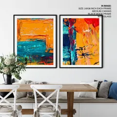 This set of two colorful abstract paintings brings bold energy to a dining space. The textured brushstrokes in orange and teal, housed in sleek black wood frames, create a dynamic and contemporary feel.