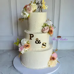 This elegant three-tier cake was designed for a beautiful beginning. It features a subtle floral stencil pattern, soft pastel blooms, and the couple's initials in gold for a personalized touch.