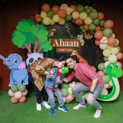 A loving family moment captured at our jungle safari party. The detailed backdrop with multiple animals creates a vibrant and exciting setting for photos.