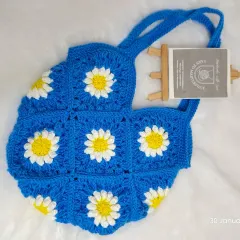 I love how the classic white and yellow daisies look against this vibrant blue. This granny square shoulder bag is perfect for casual outings and is handmade from soft but sturdy cotton yarn.