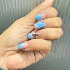 A beach-themed manicure with a blue ombre base and hand-painted palm tree silhouettes for a perfect vacation vibe.