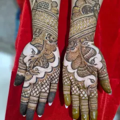 A gorgeous full-hand bridal mehendi featuring majestic peacock motifs. The design uses negative space to make the peacocks the main focus of the artwork.