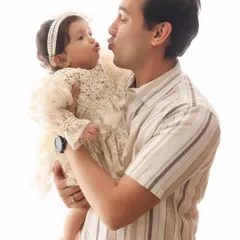 A sweet, puckered-up kiss between a father and his baby. This adorable and funny moment perfectly captures the love and lightheartedness of fatherhood.