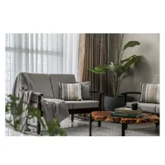 A comfortable and classic seating arrangement in the apartment's living area. The neutral grey sofa is complemented by a live-edge wood coffee table and indoor plants, adding a touch of nature.