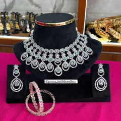 A modern and chic AD necklace set with matching earrings and bangles. The pastel green stones make it a perfect choice for engagement parties or pre-wedding events.
