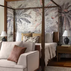 In this master suite, the four-poster bed creates an intimate sanctuary within a large, open room. I chose a botanical wallpaper to serve as a dramatic, artistic backdrop, adding depth and a connection to nature. It’s a perfect example of how we design multi-functional bedrooms that are not just for sleep, but for living and retreating.