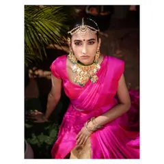 A portrait that exudes royalty. The intricate jewelry, the vibrant pink saree, and the direct, confident gaze of the model create a powerful and majestic image.