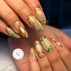 An ornate and luxurious design featuring sculpted gold lines over a shimmery cat-eye base. The look is completed with carefully placed colorful gems for a jewelry-like effect.