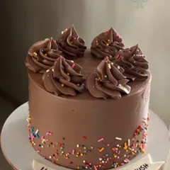 You can't go wrong with a classic chocolate cake. This one is simply decorated with chocolate swirls and colorful sprinkles, making it a timeless choice for any birthday.