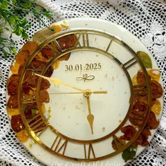 A beautiful shot of a custom resin wall clock made with preserved varmala flowers. The white background and gold Roman numerals create a timeless and elegant look, making it a perfect addition to any home.