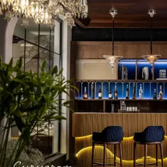 The basement in the House of Two Worlds is conceived as a dedicated social zone, separate from the main living areas. This bar and lounge area is designed for large-scale entertainment, featuring acoustic zoning and an immersive character for hosting guests.