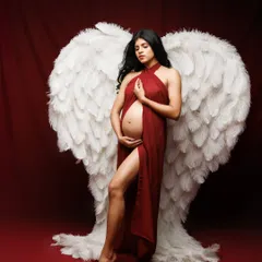 A powerful and artistic concept for Valentine's Day, combining the passion of a red fabric drape with the purity of white angel wings. It symbolizes a mother's fierce, protective love.