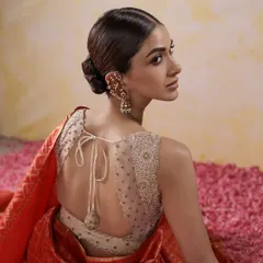 A modern take on the bridal blouse, featuring a sheer back with scattered beadwork and an elegant tie-up tassel. This design offers a contemporary feel while maintaining traditional craftsmanship.