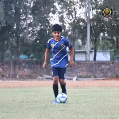 A young player confidently dribbling the ball during a training session. Our goal is to make every player comfortable and creative with the ball at their feet.