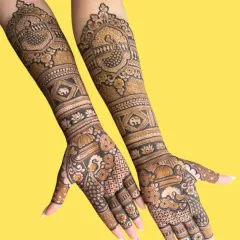 This design showcases a beautiful blend of peacock and elephant motifs, extending all the way up the arm for a full bridal look.