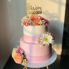 A beautiful two-tier engagement cake in shades of pink and lavender, adorned with fresh flowers. This one was a 2kg Pineapple cake, bringing a tropical flavor to the celebration.