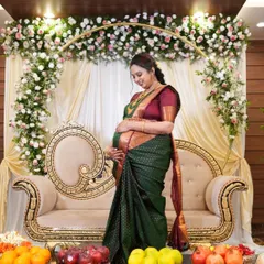 A full-length shot of Archana at her baby shower. The makeup is elegant and understated, allowing her natural happiness and the beauty of the traditional ceremony to take center stage.