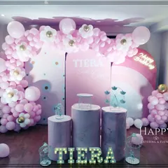 A full view of the pink balloon arch and backdrop for Tiera's first birthday. The daisy-shaped balloons add a sweet and charming detail to the overall design.
