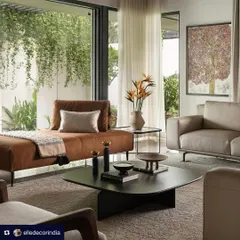 An image from the Elle Decor feature on Villa Shakthi, showcasing the living area's seamless connection to the lush green outdoors. The design uses a mix of contemporary furniture and natural light to create a serene and inviting space.