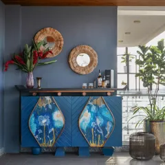A bold statement in blue, this bar cabinet features custom-painted panels with abstract floral motifs. The chevron pattern on the doors adds texture, while the dark wood top provides a durable surface for serving, making it a centerpiece for entertaining.