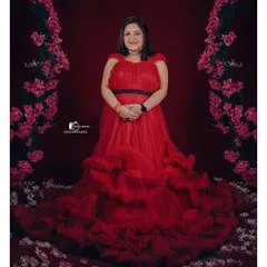 A full-length view of our popular red ruffled gown, showing how the tiered layers create a stunning, voluminous skirt. This dress is a fantastic choice for a bold and beautiful studio maternity portrait.
