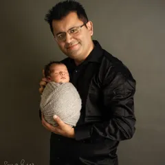 A father's strong and gentle hold, cradling his tiny, sleeping son. This classic father and baby portrait is a powerful symbol of protection and love.