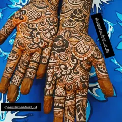 This design shows a beautiful mix of styles, with traditional Indian patterns on the fingers and a bold floral and leaf design flowing from the wrist.