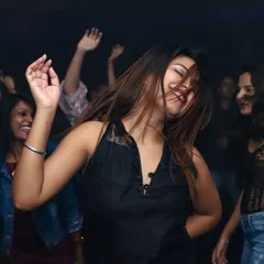 A happy partygoer enjoying the music at one of my luxury nightclub residencies. My goal is always to play the tracks that make you want to dance all night long, creating memorable nightlife experiences.