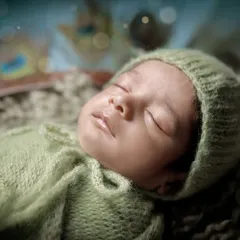 A detailed close-up of the baby's serene face during our Little Krishna photoshoot. We ensure your baby is always comfortable and peaceful, even in our most elaborate setups.