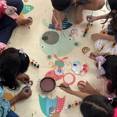 Here is a bird's-eye view of a typical day at the club. Kids gathered on the floor, sharing paints and ideas, completely lost in their creative world. We foster a collaborative and comfortable environment where friendships blossom right alongside artistic skills.
