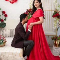 A classic and powerful portrait of love and anticipation. The rich red satin gown against the floral backdrop creates a feeling of romance and celebration. A father's gentle kiss on the belly is a gesture of protection and deep affection that I am honored to capture.