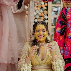 A moment of pure, unadulterated joy as the bride is showered with flower petals and water during her 'Mangal Snanam' ritual, a beautiful South Indian tradition we incorporated into her Haldi.