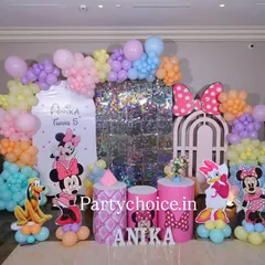This Minnie Mouse birthday party is a pastel dream. The setup includes a shimmering sequin panel, a custom arch, and character cutouts of Minnie, Daisy, and Pluto, all tied together with a soft, multi-colored balloon garland.