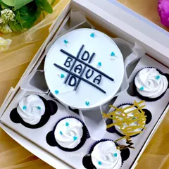 A simple and sweet bento set for a sibling, with 'Didi Bada' written on the cake in a tic-tac-toe design. The minimalist black and white theme is carried over to the accompanying cupcakes.