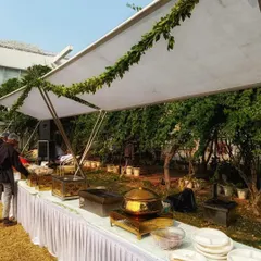 My decor services extend to outdoor catering setups to ensure a consistent aesthetic. For this daytime event, I used a clean, white canopy elegantly draped with simple green foliage to create a fresh and sophisticated dining area.