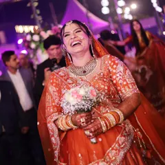 The pure, unadulterated laughter of the bride during her entrance. This candid shot is full of life and happiness.